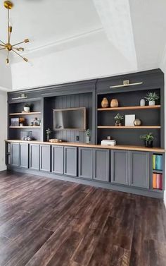 an image of a living room with gray cabinets and wood flooring on the walls