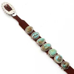 Experience the breathtaking charm of the Charles Rogers Navajo bracelet. Featuring seven exquisite turquoise stones, this bracelet is a striking fashion statement. The 3/4" x 1/2" center stone and luxurious brown leather create a striking juxtaposition, fastened with a dazzling sterling silver buckle. Adjustable to fit wrists up to 9" in circumference, the product image accurately portrays the one-of-a-kind item you will receive. Southwestern Brown Bracelets, Southwestern Brown Jewelry With Patina, Brown Southwestern Jewelry With Patina, Turquoise Leather Concho Jewelry, Southwestern Turquoise Leather Jewelry, Southwestern Brown Leather Jewelry, Southwestern Style Brown Leather Jewelry, Western Leather Jewelry With Concho, Southwestern Style Brown Bracelet Jewelry