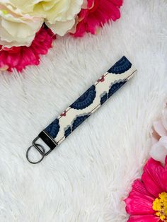 a blue and white umbrella strap with flowers in the background on a furry surface,