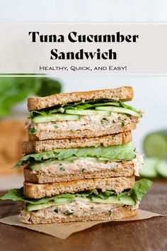 a stack of sandwiches with tuna and cucumber sandwich toppings on top, sitting on a cutting board