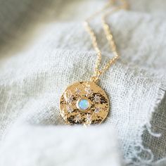 "Beautiful and lovely dainty round pendant with opal stone necklace. Made of tiny CZ stone stars and opal stone round pendant with skinny gold plated brass chain. Lobster clasp closure. Soft and warm. Perfect paired with any outfit or great gift item. Your beautiful necklace will ship in a gift box. If you have any questions, please feel free to contact me. Thanks :) ♥Necklace chain length 14\"-20\" ♥Round pendant 3/4\" ♥Gold plated over brass / White opal / Cubic Zirconia ♥ See more Rudiana Acc Celestial Round Birthstone Necklaces, Round Celestial Birthstone Necklace, Celestial Opal Necklace As A Gift, Celestial Opal Necklace As Gift, Celestial Opal Round Necklace, Unique Opal Round Pendant Necklace, Celestial Gold Opal Necklace, Celestial Opal Necklace For Gift, Tulip Necklace