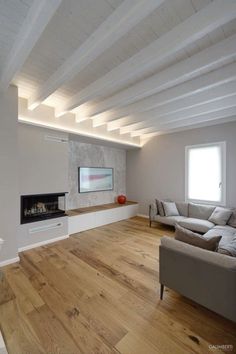 an empty living room with white walls and wood flooring is seen in this image