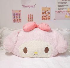 a large pink stuffed animal laying on top of a bed