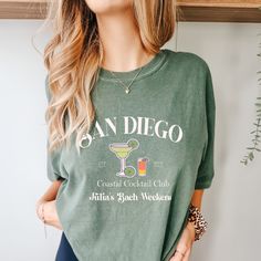 "The San Diego Bachelorette Trip Shirts are the perfect choice for a trendy and stylish bachelorette celebration in a coastal paradise. These shirts feature a design that captures the laid-back and beachy vibes of San Diego, creating a chic and fashionable look for the trip. Made with high-quality materials, these shirts ensure both comfort and style as the bride and her squad explore the beautiful beaches, soak up the sun, and create unforgettable memories during their San Diego bachelorette trip. Get ready to embrace the coastal charm and make the most of your trendy bachelorette celebration with the San Diego Bachelorette Trip Shirts, a perfect keepsake of your fabulous coastal adventure. 💙How To Order?🧡 𝟏. Choose your shirt Size, 𝟐. Choose your shirt Color, 𝟑. Select the quantity, Casual Summer Tops For Bachelorette Party, Casual Short Sleeve Tops For Bachelorette Party, Casual Crew Neck Top For Bachelorette Party, Casual Tops For Spring Bachelorette Party, Casual Cotton Tops For Bachelorette Party, Relaxed Fit Crew Neck Top For Bachelorette Party, Casual T-shirt For Bachelorette Party In Summer, Summer Crew Neck Tops For Bachelorette Party, Casual Summer T-shirt For Bachelorette Party