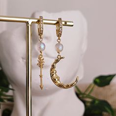 The mystical figure of Artemis, Goddess of the Hunt but also deeply connected to the Moon, is enhanced by these earrings made of 14k gold plated brass, cubic zirconia crystals and splendid glass beads with iridescent shades, which recall the colors and magical atmospheres of the moon. The one-touch hoops are studded with cubic zirconia crystals, as is the arrow, symbol of the Goddess. The best gift for any Greek Mythology obsessed or to treat yourself! - Materials: 14k gold plated brass, cubic z Moon Goddess Jewelry, Dark Academia Jewelry, Artemis Goddess, Goddess Of The Hunt, Goddess Earrings, Arrow Symbol, Locket Earrings, Cottagecore Jewelry, Customizable Jewelry