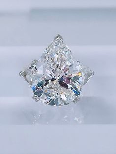 a diamond ring with three pear shaped diamonds on it's sides and the center stone in