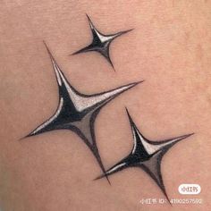 three black and white tattoos on the back of a woman's thigh, with four pointed