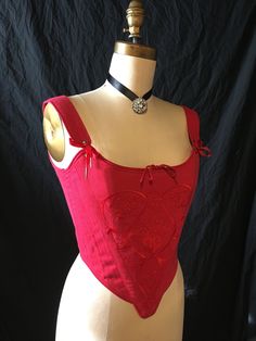 "History is beautiful with this embroidered red linen 18th century stays. This c.1770's corset achieves the conical shape required during the 18th century, using 1/2\" steel bones and horizontal boning across the bust. There is little shaping under the bust, and the bust is pushed up to a higher position. This style has shoulder straps attached with adjustable front ribbon lacing. It is made in a cranberry red linen with matching red ribbon laces at the back. The stomacher front of the corset is Fitted Bodice For Larp, Red Fitted Corset With Boning, Red Corset With Boning, Red Fitted Bodice Corset With Boning, Red Overbust Bodice With Boning, Red Boned Overbust Bodice, Red Overbust Boned Bodice, Fitted Red Bodice With Corset Back, Red Wedding Corset With Fitted Bodice