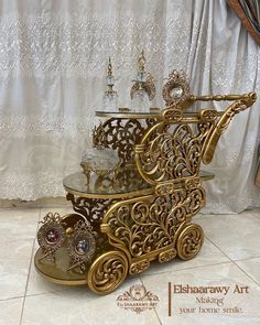 an ornately decorated gold carriage is on display in front of a white lace curtain