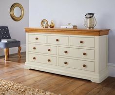 a white dresser with wooden drawers in a room