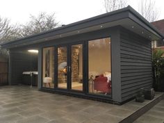 a small gray house with sliding glass doors