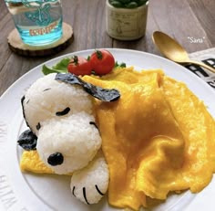 a white plate topped with food on top of a wooden table next to utensils