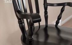 a black wooden chair sitting on top of a hard wood floor