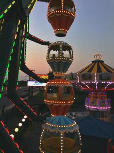 an amusement park with lights and rides at dusk