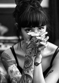 a woman with tattoos covering her face and hands