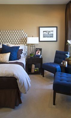 a bed room with a neatly made bed and two chairs