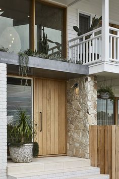 the front entrance to an apartment building with wooden doors and planters on either side