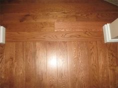 an empty room with wood flooring and white cabinet doors on the wall above it