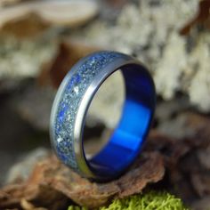 a blue ring sitting on top of moss covered ground