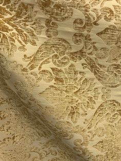 an image of a gold and white wallpaper with floral designs on it's surface