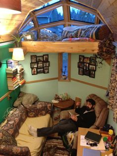 a man sitting in a small room reading a book