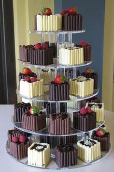 a tiered cake with chocolate and white frosting on it, topped with strawberries