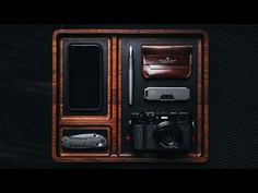 a camera, pen and other items in a wooden box on a black background photo