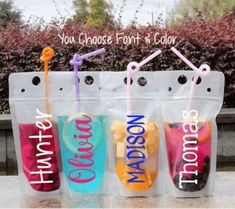 three plastic bags filled with different types of drinks and straws on top of a table