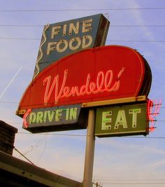 an old neon sign for a fine food drive - thru restaurant in the middle of town