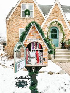 a mailbox is decorated with christmas wreaths and books in front of a brick house