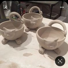 three ceramic cat bowls sitting on top of a table