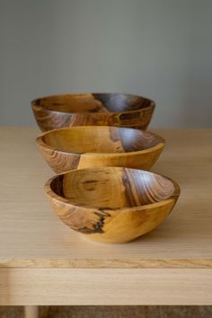 three wooden bowls sitting on top of a table