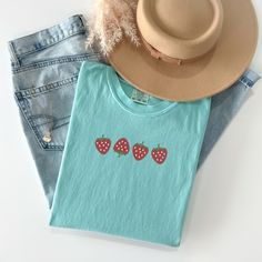 Welcome the sunny days with our delightful Summer Strawberry Embroidered T-Shirt! Made from 100% cotton, this t-shirt is not only comfortable but also perfect for staying cool during warm weather. Available in sizes S to 2XL and nine vibrant colors including Banana, Bay, Blossom, Butter, Chalky Mint, Chambray, Ivory, Orchid, and Peachy, there's a shade to suit every style.The standout feature of this t-shirt is the charming summer fruit-inspired design, showcasing four intricately embroidered strawberries on the center chest. Whether you're heading to a picnic, beach outing, or simply enjoying a leisurely day, this t-shirt adds a touch of sweetness to your summer wardrobe.Please note that colors may vary slightly due to monitor settings. For accurate sizing, refer to the size charts provid Cute Spring Tops In Organic Cotton, Summer Everyday T-shirt With Embroidered Text, Cute Organic Cotton T-shirt For Spring, Cute Embroidered Cotton Shirt, Cute Embroidered T-shirt For Spring, Spring Everyday Top With Embroidered Text, Cute Embroidered Relaxed Fit Tops, Everyday Spring Top With Embroidered Text, Cute Embroidered Tops With Relaxed Fit