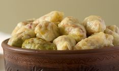 a wooden bowl filled with stuffed green peppers