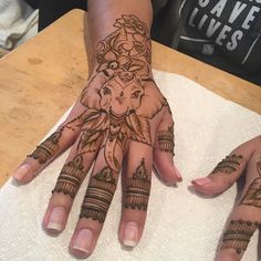 two hands with henna tattoos on them