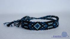 a blue and black beaded bracelet with tassels on white background, closeup