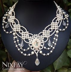 This handmade beaded necklace has a vintage style, making it a perfect accessory for a bride who wants to add a touch of timeless elegance to her wedding day look. The beads are intricately woven together, creating a delicate and intricate pattern that is sure to catch the eye. The necklace features a variety of beads in soft, muted tones, including ivory, champagne, and clear tones. These colors complement each other perfectly, creating a cohesive and harmonious design. The necklace also features a silver-toned clasp, adding a touch of sparkle and shine to the overall design. The beaded necklace is both lightweight and comfortable to wear, making it a great choice for a bride who wants to feel confident and stylish on her special day. Whether worn with a simple, understated gown or a more Bridal Beaded Jewelry, Victorian Pearl Necklace For Wedding, Handmade Baroque Necklace For Wedding, Handmade Baroque Wedding Necklace, Vintage Handmade Beaded Necklaces For Wedding, Victorian Beaded Wedding Necklace, Victorian Style Wedding Necklaces With Round Beads, Handmade Victorian Pearl Necklaces, Handmade Victorian Pearl Necklace