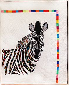 a zebra is depicted on a quilted wall hanging in front of a white background