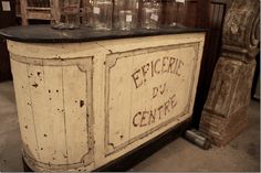 an old wooden cabinet with glass jars on top that says epicipee de centre