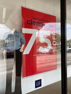 a store window with a mannequin's head in the front and an advertisement on the side