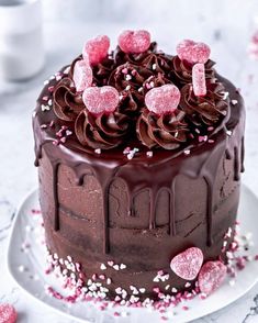 a cake with chocolate frosting and pink sprinkles on a white plate