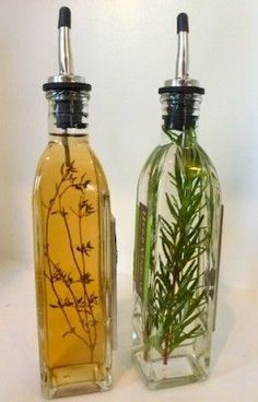 two bottles with plants in them sitting next to each other