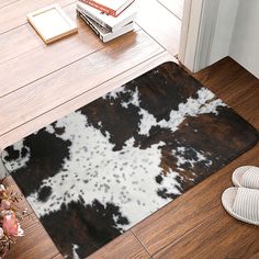 a brown and white cowhide rug on the floor next to a pair of slippers