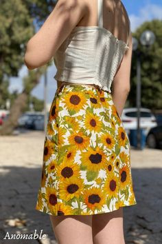 Your next favorite statement piece. Two subtle slits at the front add light detail to the summer mini skirt. A hand painted sunflowers print adorn the skirt. With warm yellow shades emanating bright, cheerful vibes, it's hard not to love this little number. The beautifully hand-painted sunflower print makes this a confidence-boosting style. The Rachel Skirt in Sunees creates a summery, colorful outfit full of vibrant energy. The floral mini skirt is made from 100% linen Summer Floral Print Skirt, Floral Print Mini Skirt For Summer Beach, Summer Day Out Printed Skirt, Printed Summer Skirt For Day Out, Vacation Floral Print Mini Skirt, Retro Flared Mini Skirt For Summer, Floral Print Summer Vacation Skirt, Summer Floral Print Mini Skirt For Vacation, Retro Floral Print Mini Skirt For Spring