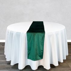 a green and white table cloth on top of a round table