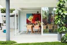 a table and chairs are in front of a painting on the wall behind them is an outdoor dining area