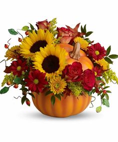 a pumpkin filled with sunflowers and roses