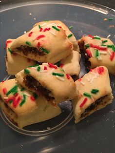 several pieces of cake sitting on top of a glass plate with confetti sprinkles