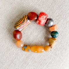 Pink, peach, yellow and greens all the bright colors of a coastal city. Features rosewood, peach jade, red coral, honey jade and jasper. African prayer beads from a weeding ceremony necklace. These prayer beads symbolize blessings, good health, happiness and long life. Comes in linen travel pouch. One of a kind. Made in USA. Bohemian Orange Beaded Bracelets With Large Beads, Bohemian Hand-strung Orange Beads, Artisan Multicolor Agate Bracelets, Hand-strung Orange Bohemian Beads, Bohemian Multicolor Agate Beaded Bracelets, Bohemian Orange Jewelry For Meditation, Spiritual Agate Beaded Bracelets With Colorful Beads, Bohemian Orange Red Coral Beads, Carnelian Beaded Bracelets With Natural Stones For Meditation