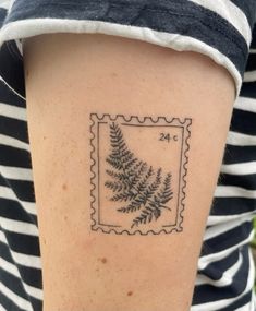 a woman's arm with a stamp on it that has a fern in it